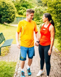 Pärchen spaziert im Sportoutfit durch Park in Leibnitz.